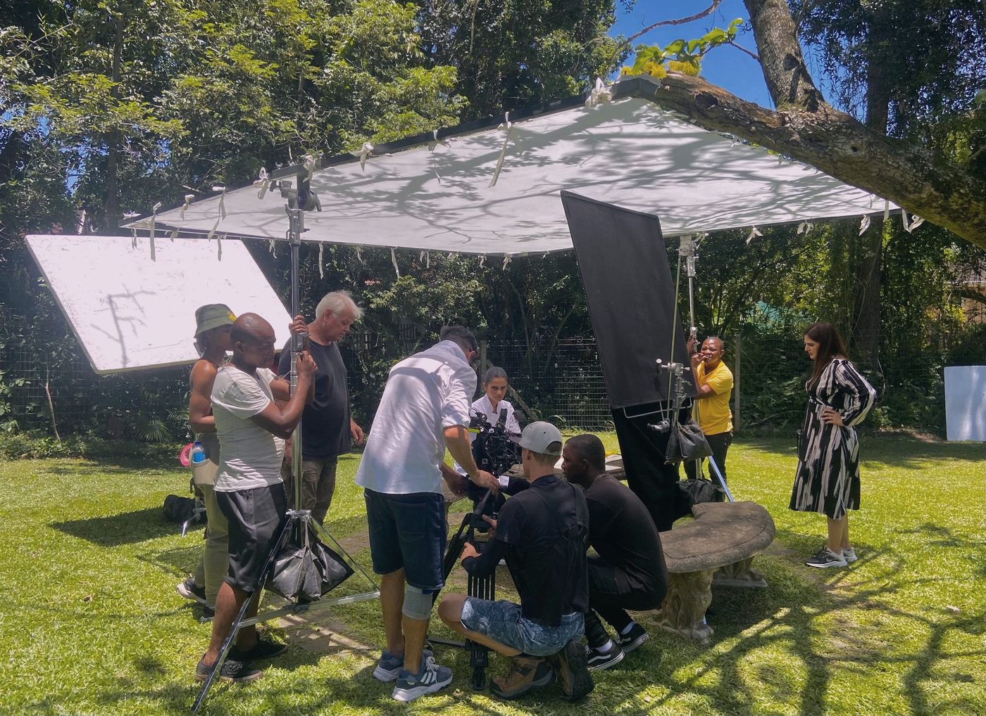 The Arthouse Pictures crew lighting a garden scene under a diffusion frame